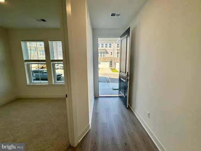 a view of hallway with a large window and wooden floor