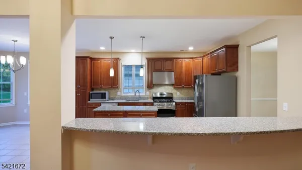 a kitchen with stainless steel appliances granite countertop a refrigerator a stove and a sink