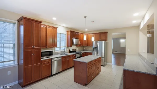 a large kitchen with a large counter top sink stainless steel appliances and cabinets