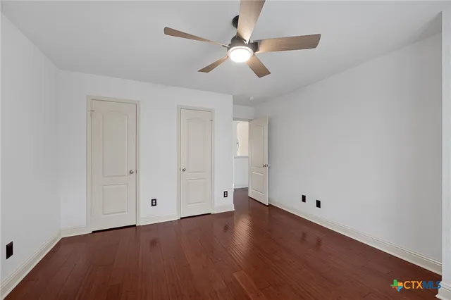 a view of an empty room with wooden floor