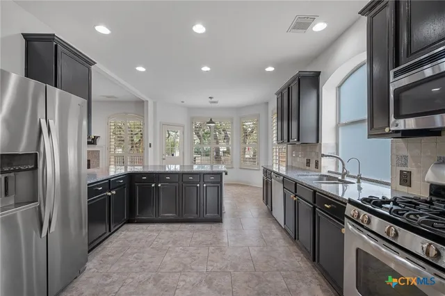 a large kitchen with stainless steel appliances double sink and stainless steel appliances