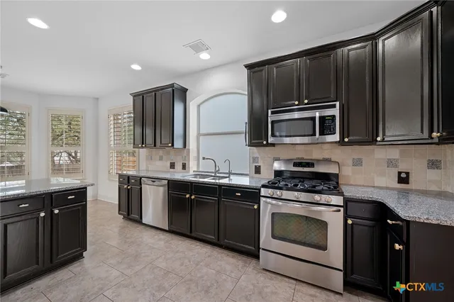 a kitchen with a sink stove and microwave