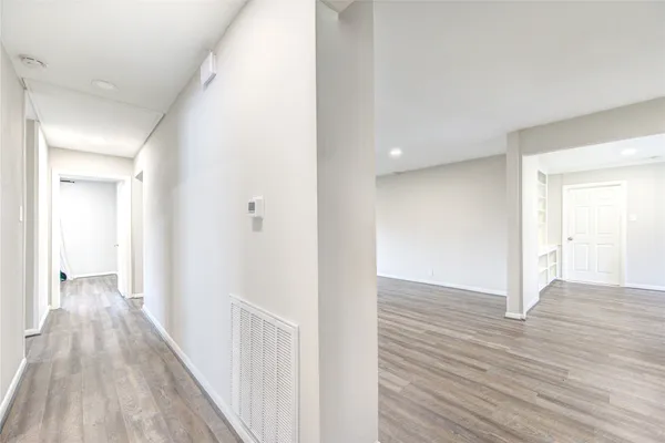 a view of a hallway with wooden floor
