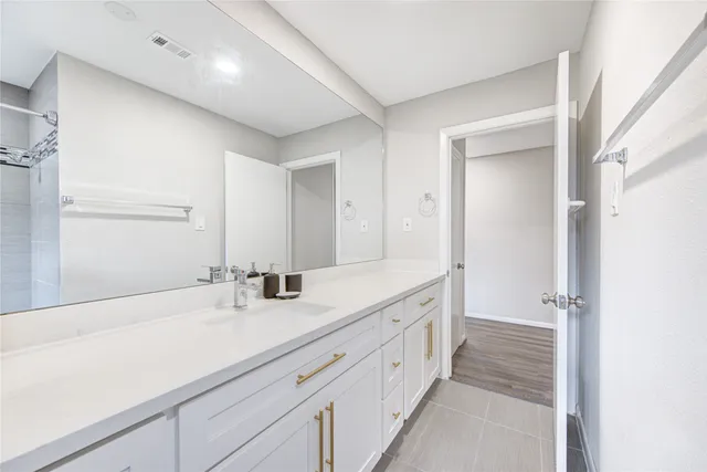a spacious bathroom with double sink and a large mirror