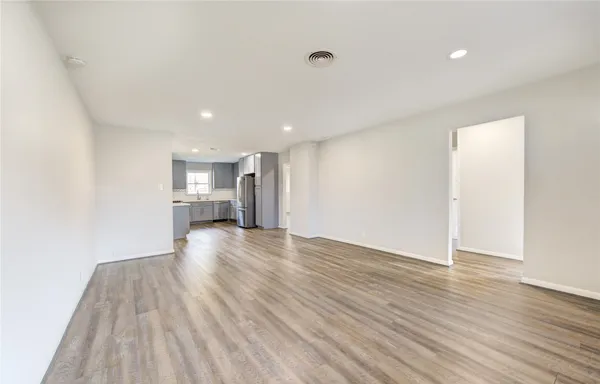 a view of empty room with wooden floor