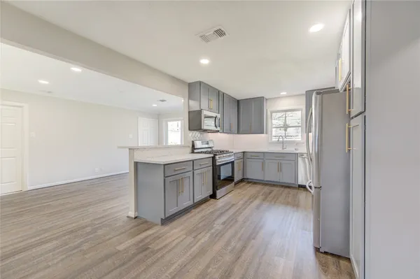 a kitchen with a white wooden floors a sink and a refrigerator