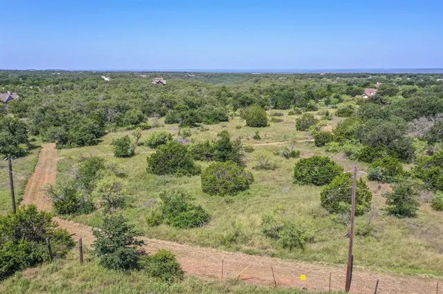 a view of a green field with lots of bushes