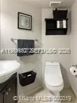 a bathroom with a toilet a sink and a mirror