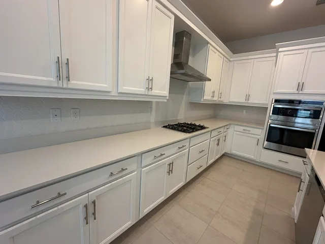 a kitchen with kitchen island a sink appliances and cabinets