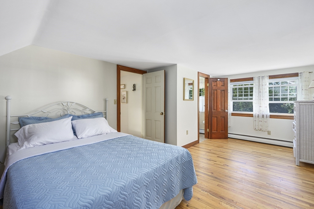216 Forest Beach Road Chatham, MA 02659 - Photo 19 of 42 a bedroom with a large bed and wooden floor