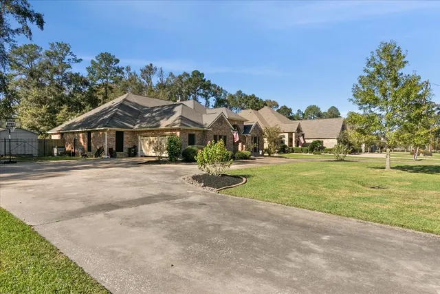 a view of house with outdoor space and trees in the background
