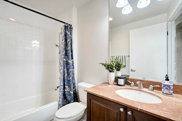 a bathroom with a granite countertop sink toilet a mirror a vanity and shower