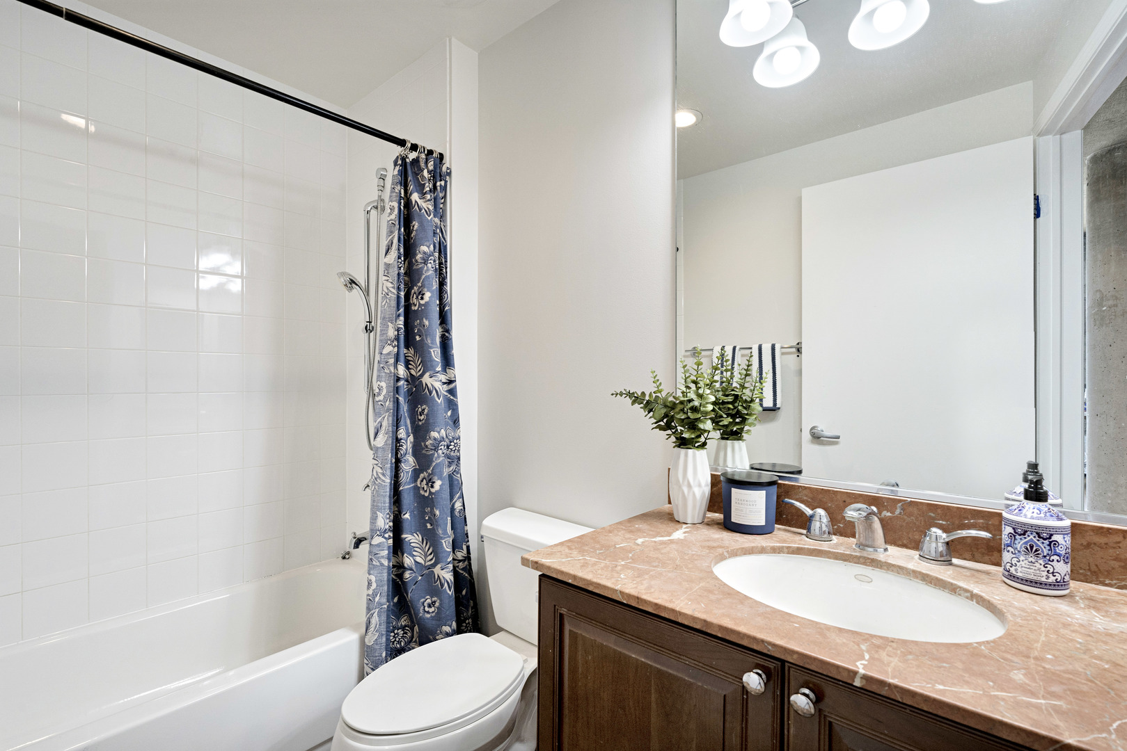 125 East 13th Street, Unit 1213 Chicago, IL 60605 - Photo 15 of 21 a bathroom with a granite countertop sink toilet a mirror a vanity and shower