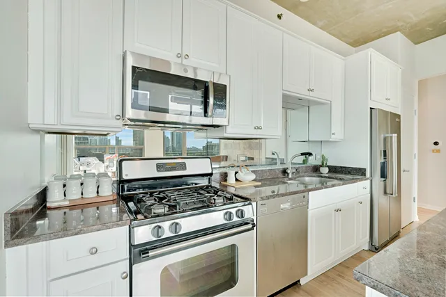 a kitchen with stainless steel appliances granite countertop a sink stove and refrigerator
