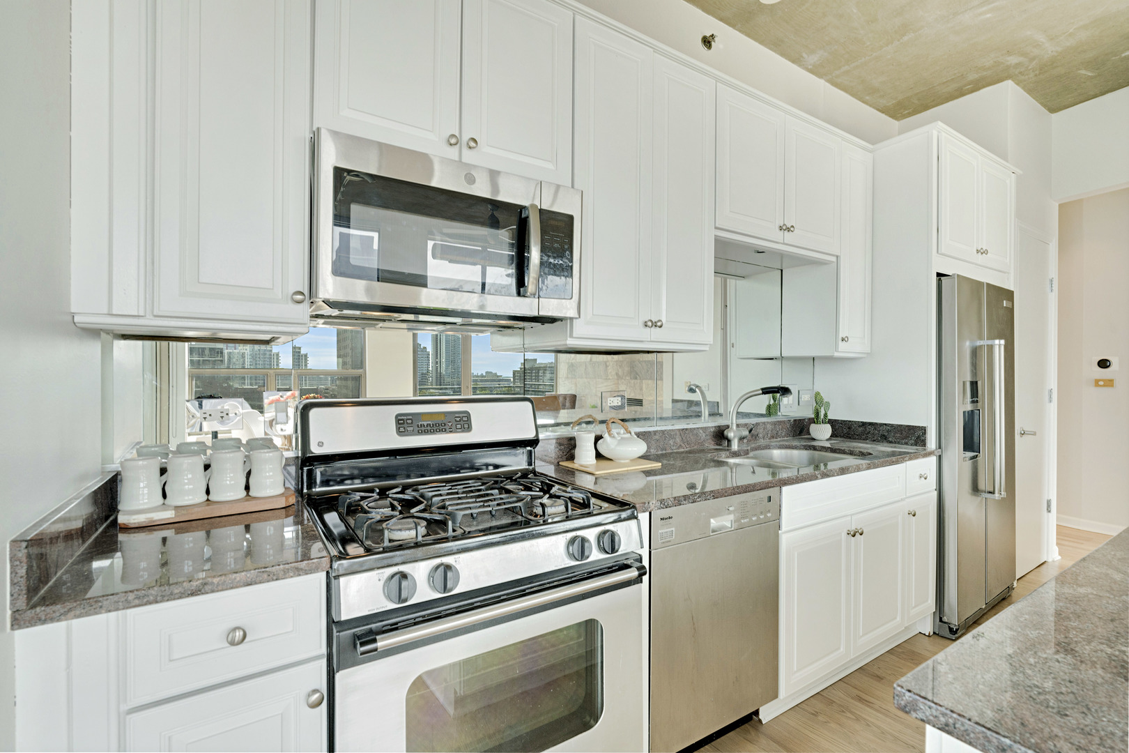 125 East 13th Street, Unit 1213 Chicago, IL 60605 - Photo 7 of 21 a kitchen with stainless steel appliances granite countertop a sink stove and refrigerator