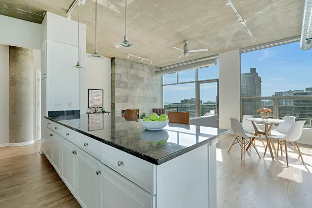 a kitchen with granite countertop a table chairs stove a sink and dishwasher