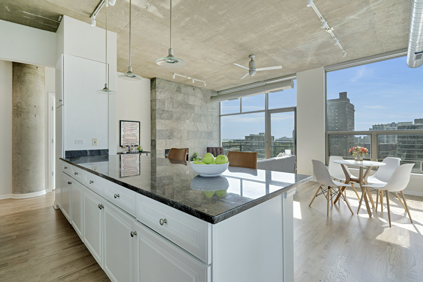 125 East 13th Street, Unit 1213 Chicago, IL 60605 - Photo 8 of 21 a kitchen with granite countertop a table chairs stove a sink and dishwasher