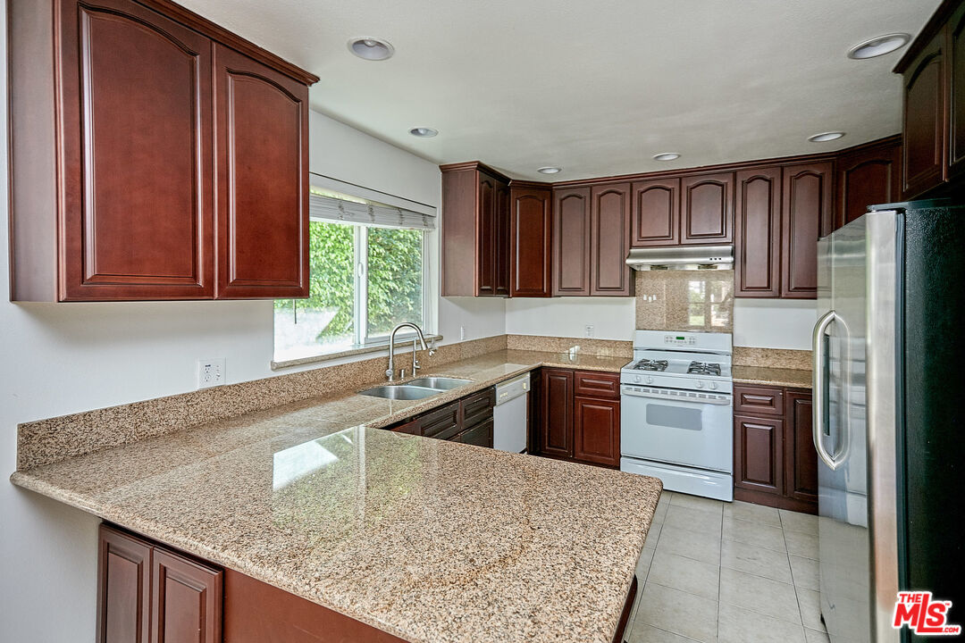 1253 Keniston Avenue Los Angeles, CA 90019 - Photo 11 of 35 a kitchen with a refrigerator sink and stove