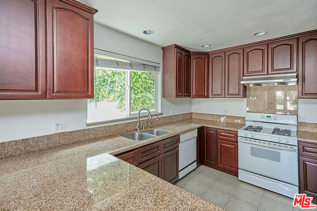 1253 Keniston Avenue Los Angeles, CA 90019 - Photo 12 of 35 a kitchen with stainless steel appliances granite countertop a sink stove and cabinets