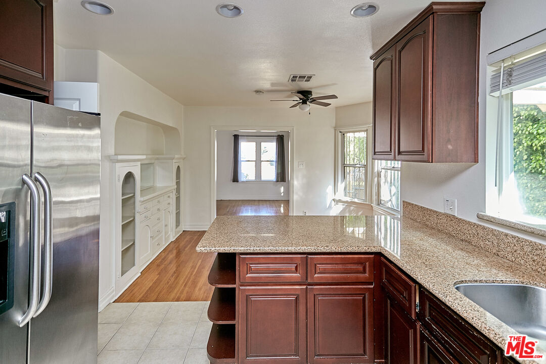 1253 Keniston Avenue Los Angeles, CA 90019 - Photo 13 of 35 a kitchen with stainless steel appliances granite countertop a sink a stove and refrigerator