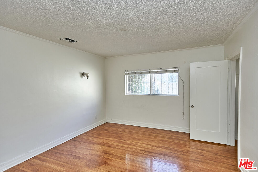 1253 Keniston Avenue Los Angeles, CA 90019 - Photo 15 of 35 a view of empty room with wooden floor and fan