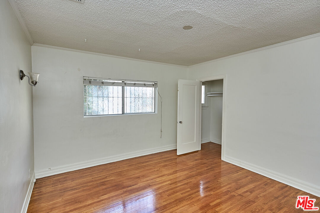 1253 Keniston Avenue Los Angeles, CA 90019 - Photo 16 of 35 a view of an empty room with wooden floor and a window