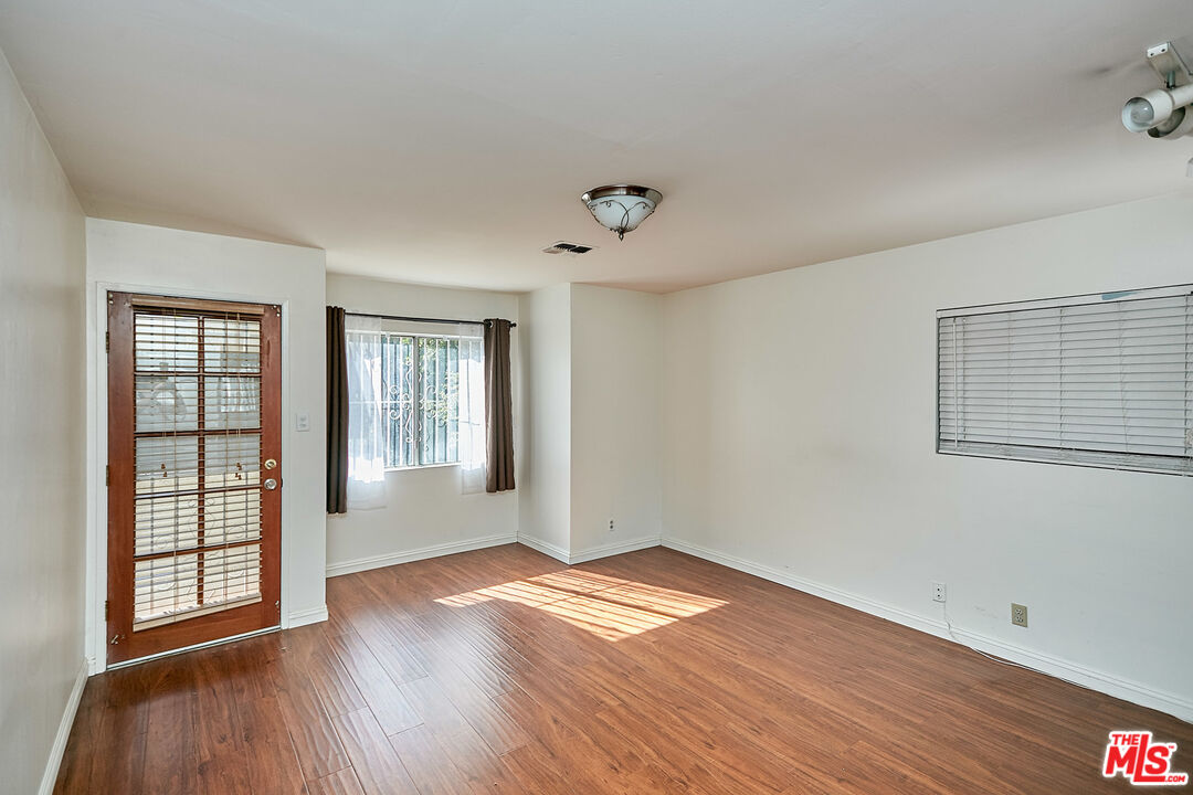 1253 Keniston Avenue Los Angeles, CA 90019 - Photo 21 of 35 an empty room with wooden floor and windows