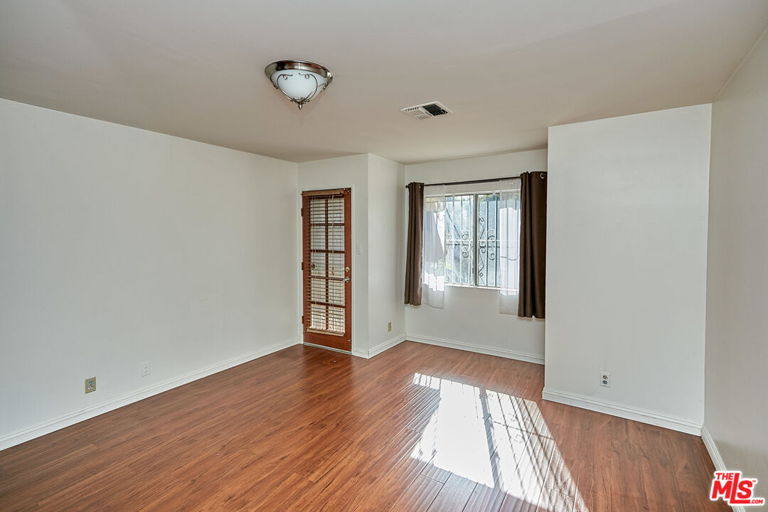 1253 Keniston Avenue Los Angeles, CA 90019 - Photo 22 of 35 a view of an empty room with wooden floor and a window
