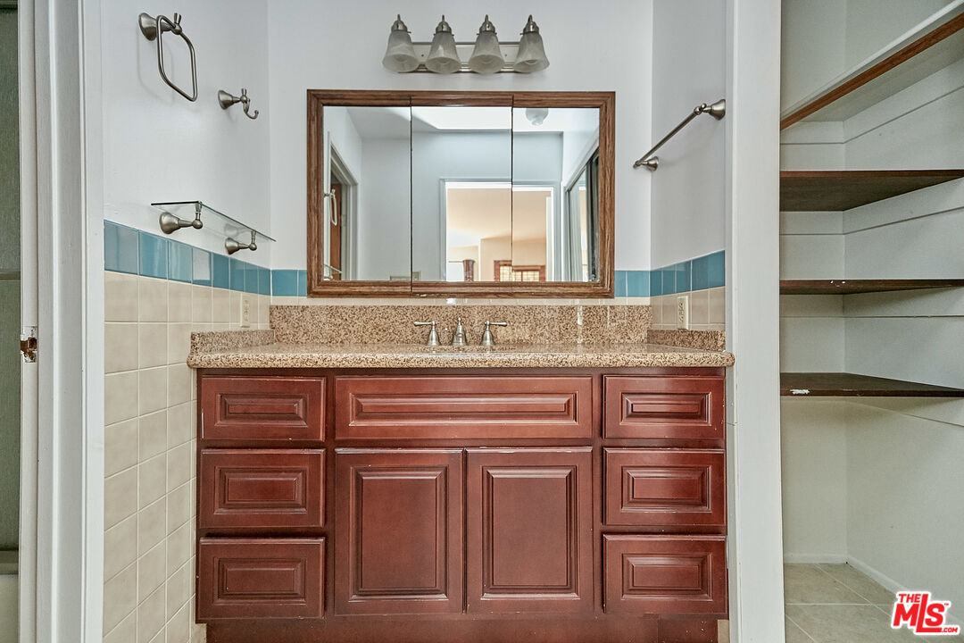 1253 Keniston Avenue Los Angeles, CA 90019 - Photo 25 of 35 a bathroom with a sink vanity and a mirror