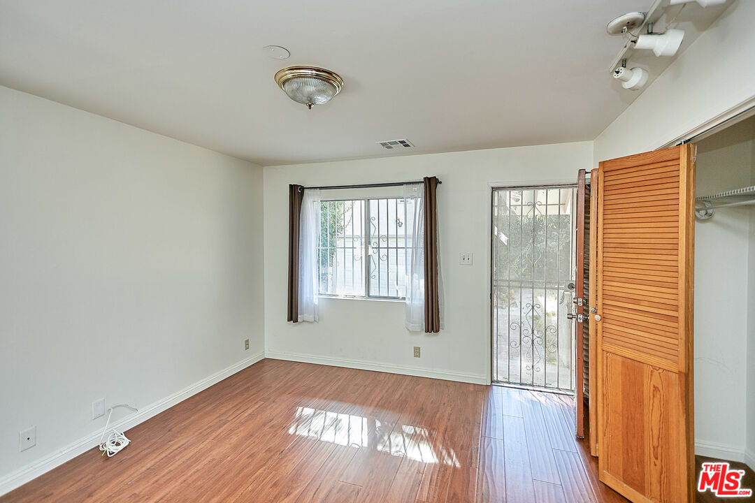 1253 Keniston Avenue Los Angeles, CA 90019 - Photo 30 of 35 a view of an empty room with wooden floor and a window