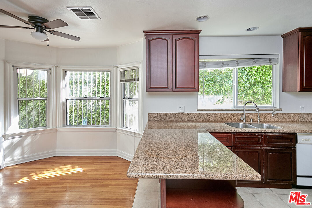 1253 Keniston Avenue Los Angeles, CA 90019 - Photo 31 of 35 a kitchen with kitchen island granite countertop a sink window and cabinets