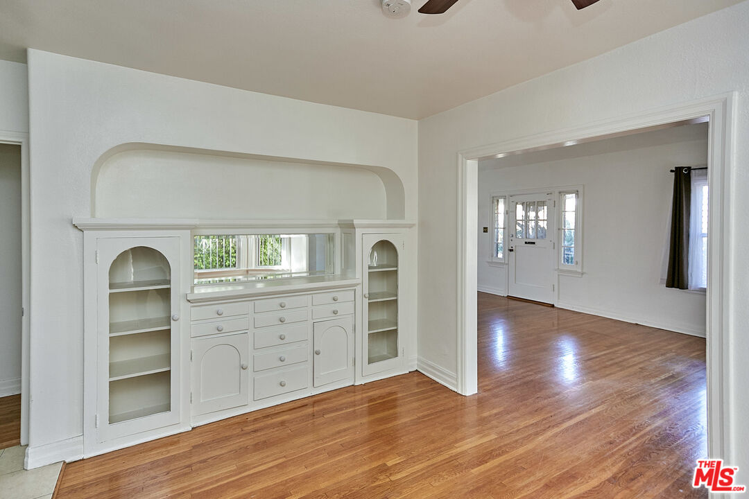 1253 Keniston Avenue Los Angeles, CA 90019 - Photo 33 of 35 a view of empty room with wooden floor and cabinet