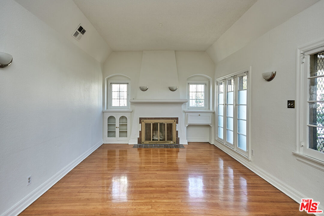1253 Keniston Avenue Los Angeles, CA 90019 - Photo 5 of 35 a view of a livingroom with wooden floor and a fireplace