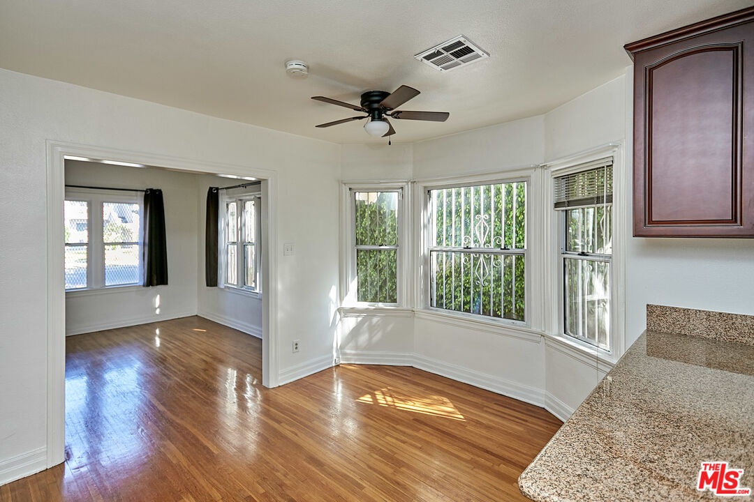 1253 Keniston Avenue Los Angeles, CA 90019 - Photo 7 of 35 a view of an empty room with a window and wooden floor