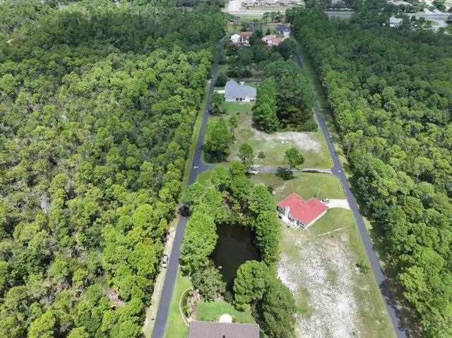 an aerial view of residential house with outdoor space and trees all around