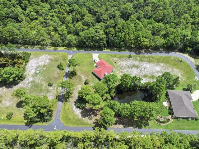 an aerial view of residential house with outdoor space and a lake view