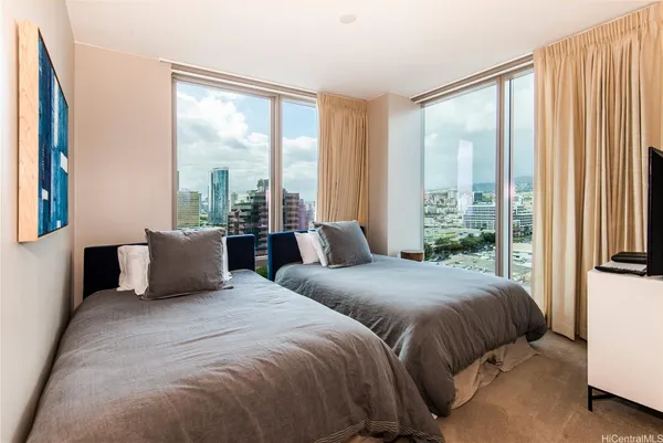 a bedroom with two beds and a large window