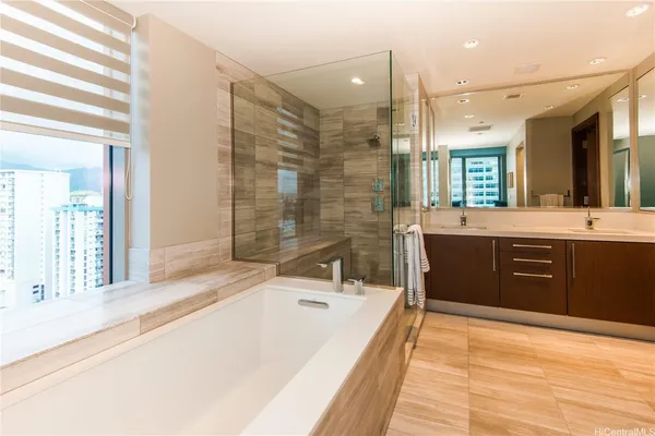 a spacious bathroom with a tub sink shower and mirror