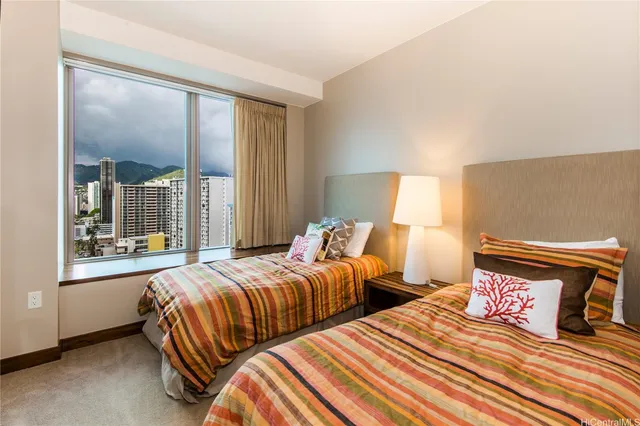 a bedroom with two beds and large window