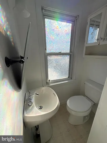 a bathroom with a toilet a sink and a mirror