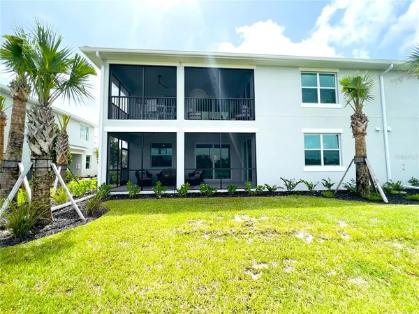 a front view of a house with garden and trees
