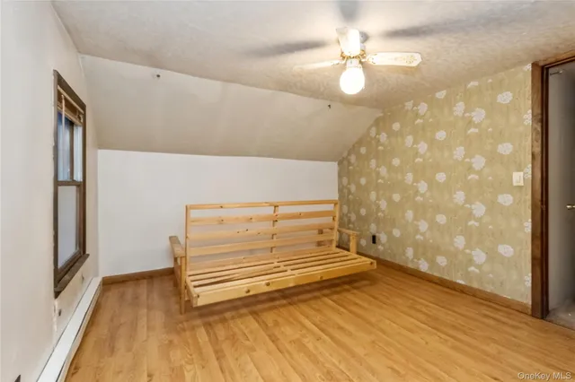 a view of a room with wooden floor and a ceiling fan
