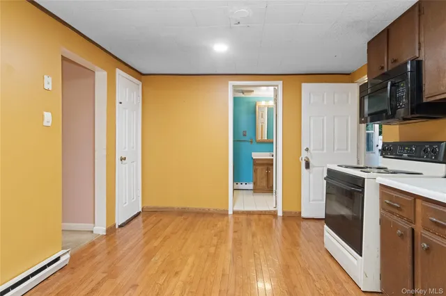 a view of a kitchen with a stove wooden floor and a kitchen