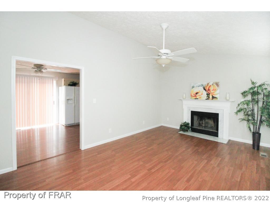5026 Summer Ridge Road Fayetteville, NC 28303 - Photo 4 of 23 a view of an empty room with a fireplace and wooden floor