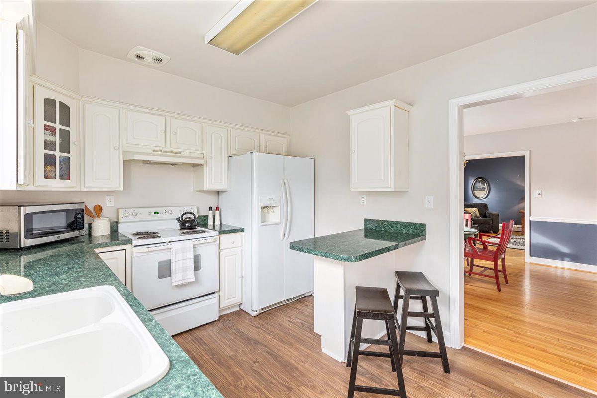 605 Happy Creek Road Front Royal, VA 22630 - Photo 8 of 19 a kitchen with stainless steel appliances kitchen island granite countertop a dining table chairs and white cabinets