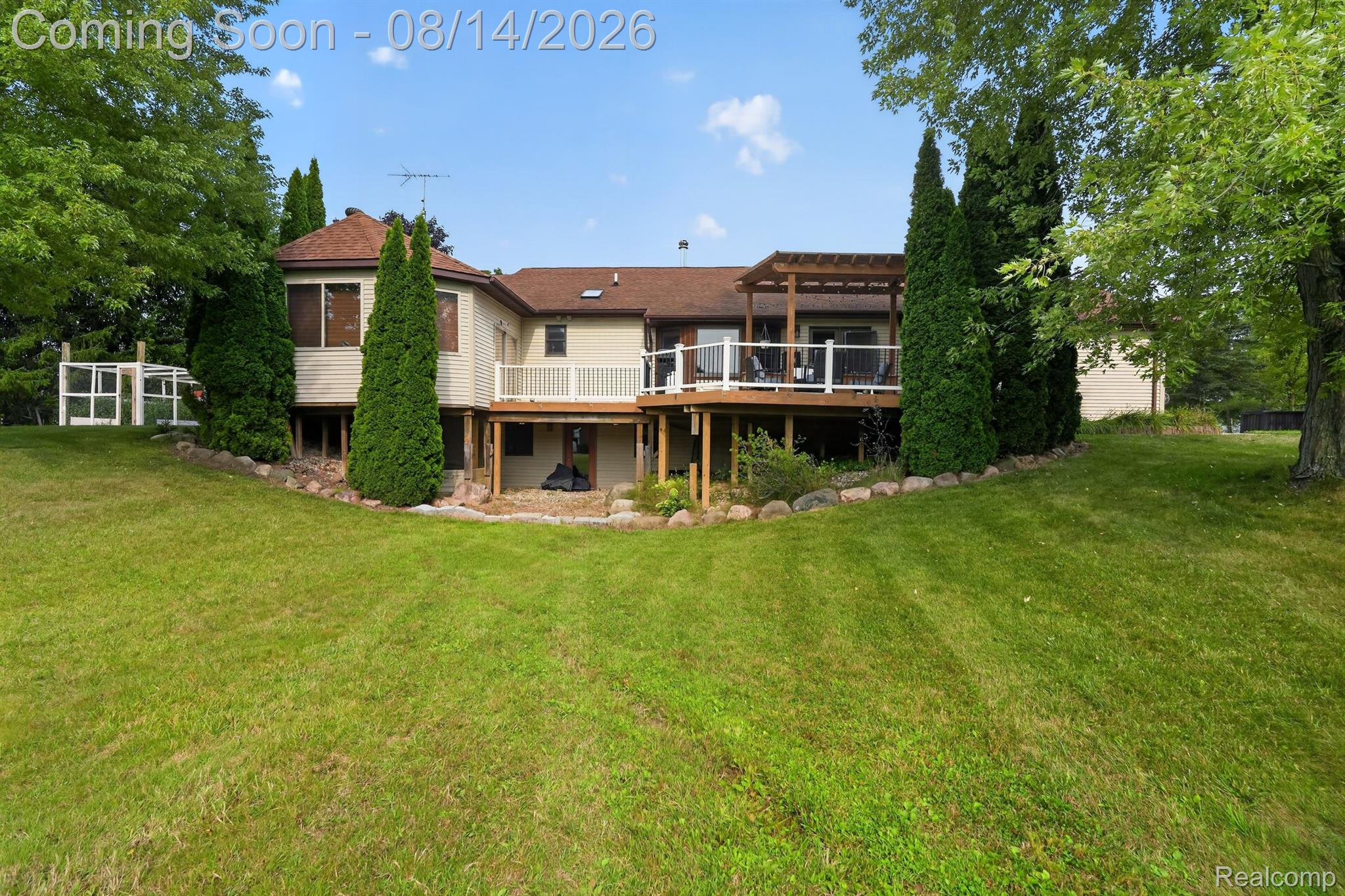 11342 South Morrish Road Gaines, MI 48436 - Photo 18 of 26 Expansive yard with sloped lawn, a multi-level deck featuring white railings, and a screened-in porch