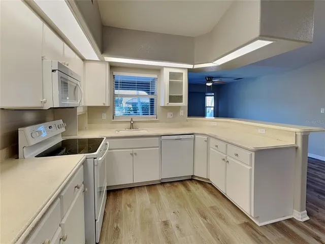 a kitchen with a cabinets window and white appliances