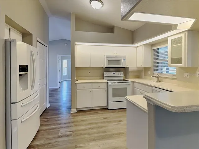 a kitchen with white cabinets and stainless steel appliances