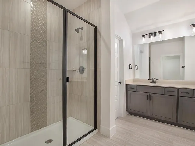 a spacious bathroom with a double vanity sink a mirror and a shower
