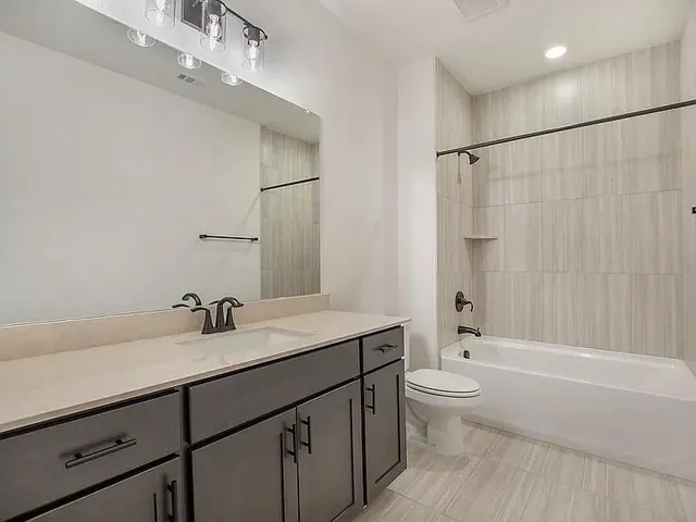 a bathroom with a sink a toilet and a large mirror